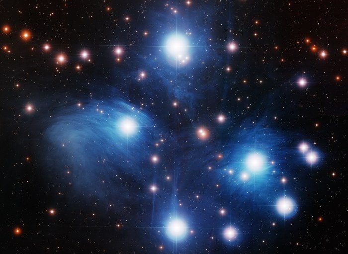 Vue rapprochée des Pléiades montrant les étoiles bleues les plus brillantes entourées de leur nébulosité de réflexion caractéristique