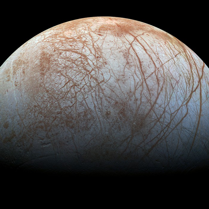 Europe, lune de Jupiter, en couleurs réalistes, montrant le réseau de failles brun-rougeâtre qui strie sa croûte de glace