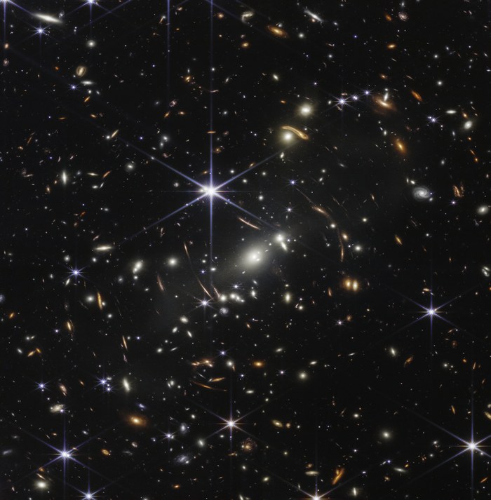 Le premier champ profond de James Webb, montrant l'amas de galaxies SMACS 0723 entouré de milliers de galaxies lointaines déformées par lentille gravitationnelle