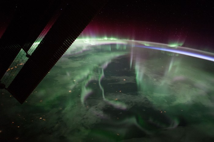 Aurore boréale photographiée depuis la Station spatiale internationale, avec un panneau solaire visible au premier plan