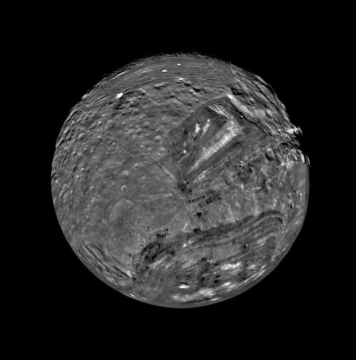 Miranda, lune d'Uranus, photographiée par la sonde Voyager 2, montrant sa surface fracturée aux formations géologiques chaotiques