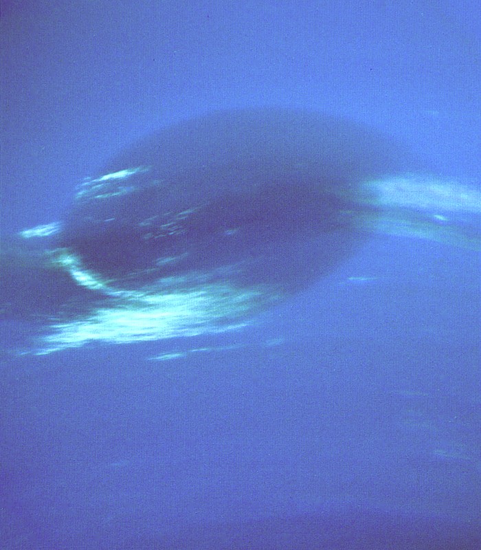 La Grande Tache Sombre de Neptune photographiée par Voyager 2 en 1989, entourée de nuages de méthane brillants